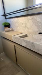 a bathroom with a marble counter with a sink at Terra Brasilis Linda vista mar, completo, aconchegante, bem localizado in Balneário Camboriú