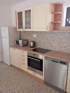 eine Küche mit weißen Schränken und einem Herd mit Backofen in der Unterkunft House Daniela in Omišalj + 14 Fotos