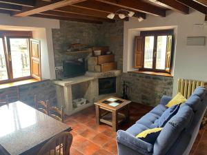 a living room with a blue couch and a fireplace at La Pipa in Cangas de Onís