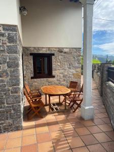 a wooden table and chairs on a patio at La Pipa in Cangas de Onís