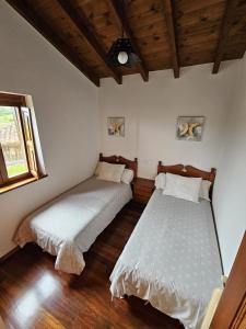 a bedroom with two beds and a window at La Pipa in Cangas de Onís