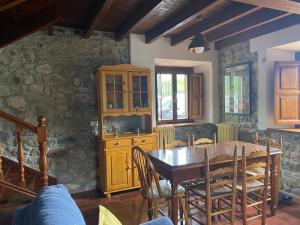 a dining room with a table and a stone wall at La Pipa in Cangas de Onís