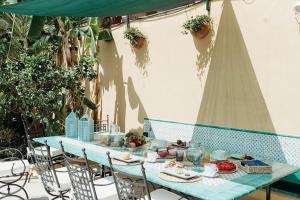 una mesa azul con comida en el patio en Villa Marta Luxury Sea View and Spa, en Taormina