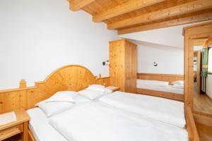 a bedroom with two beds and a desk at Frara Residence Apartments in San Cassiano
