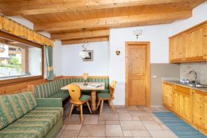 a kitchen and living room with a couch and a table at Frara Residence Apartments in San Cassiano