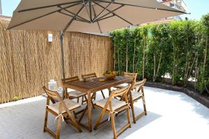 a wooden table and chairs with an umbrella at Casa Aricò in Calatabiano
