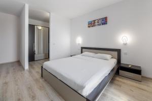a white bedroom with a large bed and a mirror at Monaco Grand Apartments By CityBookings in Bucharest