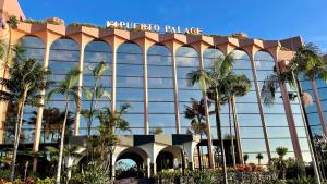 a hotel with palm trees in front of a building at Hotel Puerto Palace in Puerto de la Cruz