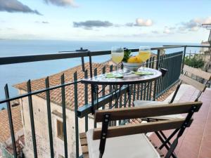 a balcony with a table with two glasses of wine at Casa Anteresa in Vietri sul Mare