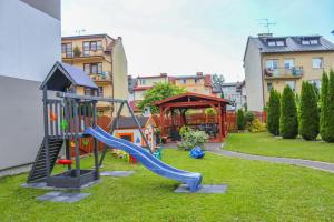 a playground with a slide in a yard at Szafir Ustka in Ustka