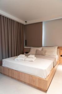 a bedroom with a large bed with white sheets at Sealuxe Living in Iraklitsa