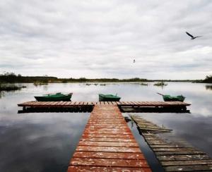 two boats are docked at a dock on a lake at Stajnia Czahary 3 in Pogorzelica