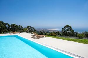 a swimming pool with a view of the ocean from a house at Casa da Serra in Buarcos