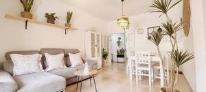 un soggiorno con un divano, un tavolo e delle sedie di Natural Home Beach - Apartamento con aire a Roquetas de Mar
