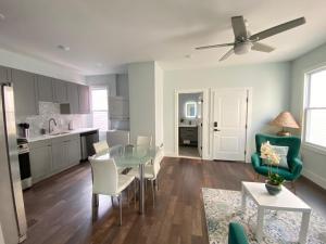 a kitchen and living room with a glass table and chairs at Modern 2BR Direct Bus to Manhattan & Times Sq in Jersey City