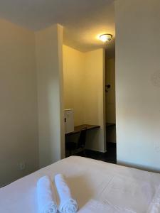 two towels sitting on top of a bed in a room at pousada sudoeste castelhana in Saquarema +4 photos
