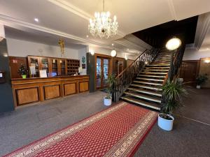 una hall con scale e lampadario pendente di Hotel Sloup a Soběslav