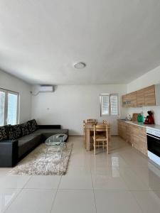 un salon avec un canapé noir et une table dans l'établissement Hida Ile apartments, à Ulcinj