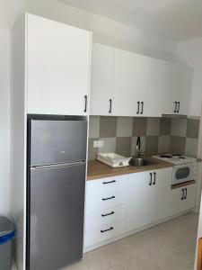 a kitchen with white cabinets and a stainless steel refrigerator at Filoxenia Kontogiannis in Lazaráta