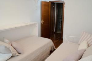 a white bedroom with two beds and a door at Fogar da Peixeira in Cambados +17 photos