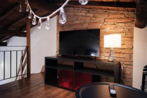 a living room with a television and a brick wall at Mamma Maria P1 in Monterotondo