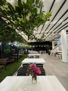 a group of tables and chairs with flowers on them at Hotel Kristal Borsh in Borsh