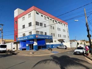 un gran edificio blanco con techo rojo en Hotel Londe, en Patrocínio