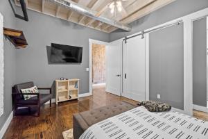a bedroom with a bed and a chair at Downtown Urban Loft above Restaurant #7 in Perryville +26 photos