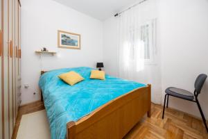 a bedroom with a bed with blue sheets and a chair at Apartment Hubi in Klis +30 photos