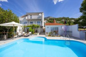 a swimming pool in front of a house at Apartment Hubi in Klis