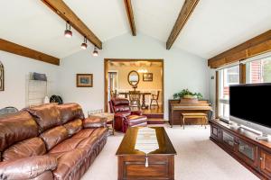 a living room with leather furniture and a flat screen tv at Duluth Lake House - Walk to Beach and Boat Ramp! in Hermantown