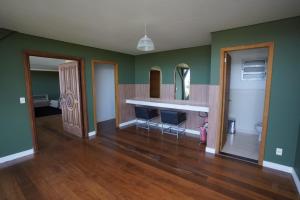 a living room with green walls and a white counter at Casa Pôr Do Sol Cantareira in Mairiporã