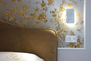 a bedroom with a bed and a wall with floral wallpaper at Sara B&B Accommodation in Santa Domenica