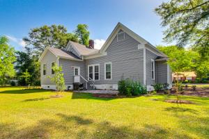 une maison grise avec une cour avec deux arbres dans l'établissement Charming Georgia Cottage about 19 Mi to Statesboro!, à Metter