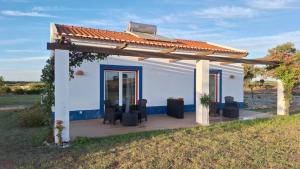 a small white house with a wooden deck at Monte da Isabel in Vale de Água