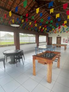 巴纳内拉斯Chalé Encantador em Bananeiras的一间设有两张乒乓球桌和五颜六色旗帜的房间 更多51张照片