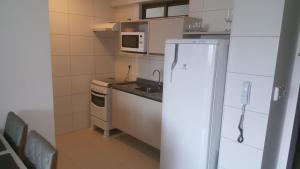 una pequeña cocina con nevera y microondas en Flat Conselheiro Aguiar 1503, en Recife