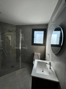 Un baño con inodoro, lavabo y espejo. en Maroulla's Urban Beach Living, en Limassol