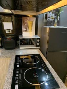 a kitchen with a stove and a microwave at Aura Suite in Imus