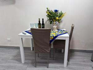 a table with a vase of flowers and bottles of wine at Casa Vacanze A CASUZZA in Marsala