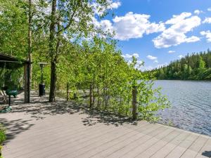 un paseo marítimo de madera junto a un lago con árboles en Holiday Home Villa torni by Interhome, en Heinävesi