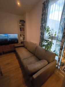 a living room with a couch and a flat screen tv at Heathrow luxury stay in Feltham