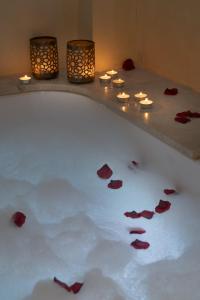 a bath tub with candles and red rose petals at Alcoba del Rey de Sevilla in Seville