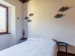 a bedroom with a bed and two stools at Apartment Martina by Interhome in Gravedona +15 photos
