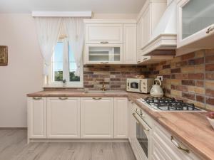 een keuken met witte kasten en een bakstenen muur bij Holiday Home Imperia by Interhome in Pridraga