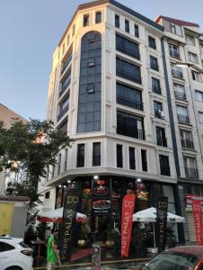 ein hohes weißes Gebäude mit einem Laden davor in der Unterkunft Pars Palas Hotel in Bostaniçi