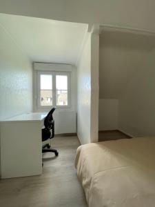 a bedroom with a desk and a chair next to a bed at Appartement rénové tout équipé, centre ville, proche de la gare et commerce in Flers