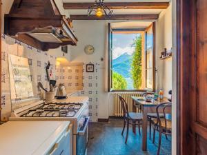 cocina con fogones, mesa y ventana en Apartment Sissi by Interhome, en Musso