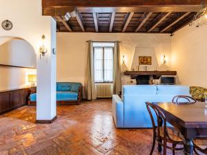 Una sala de estar con un sofá azul y una mesa. en Apartment Sissi by Interhome, en Musso