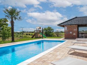a swimming pool with a playground and a house at Holiday Home Countryside estate by Interhome in Križevci